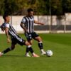 Dois jogadores de futebol estão em campo disputando pela bola de forma acirrada