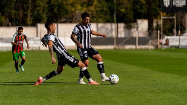 Dois jogadores de futebol estão em campo disputando pela bola de forma acirrada